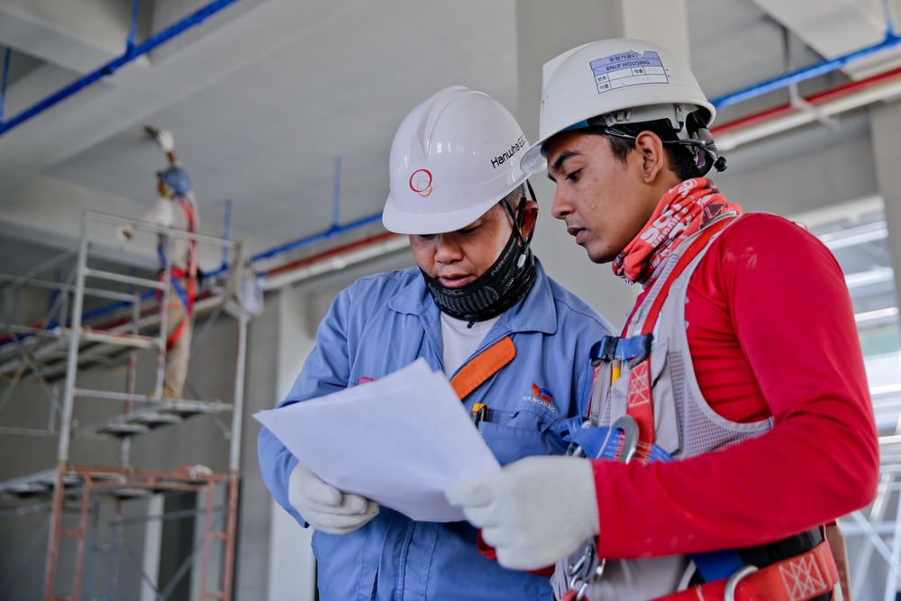 Ingenieros de construcción revisando planos en obra
